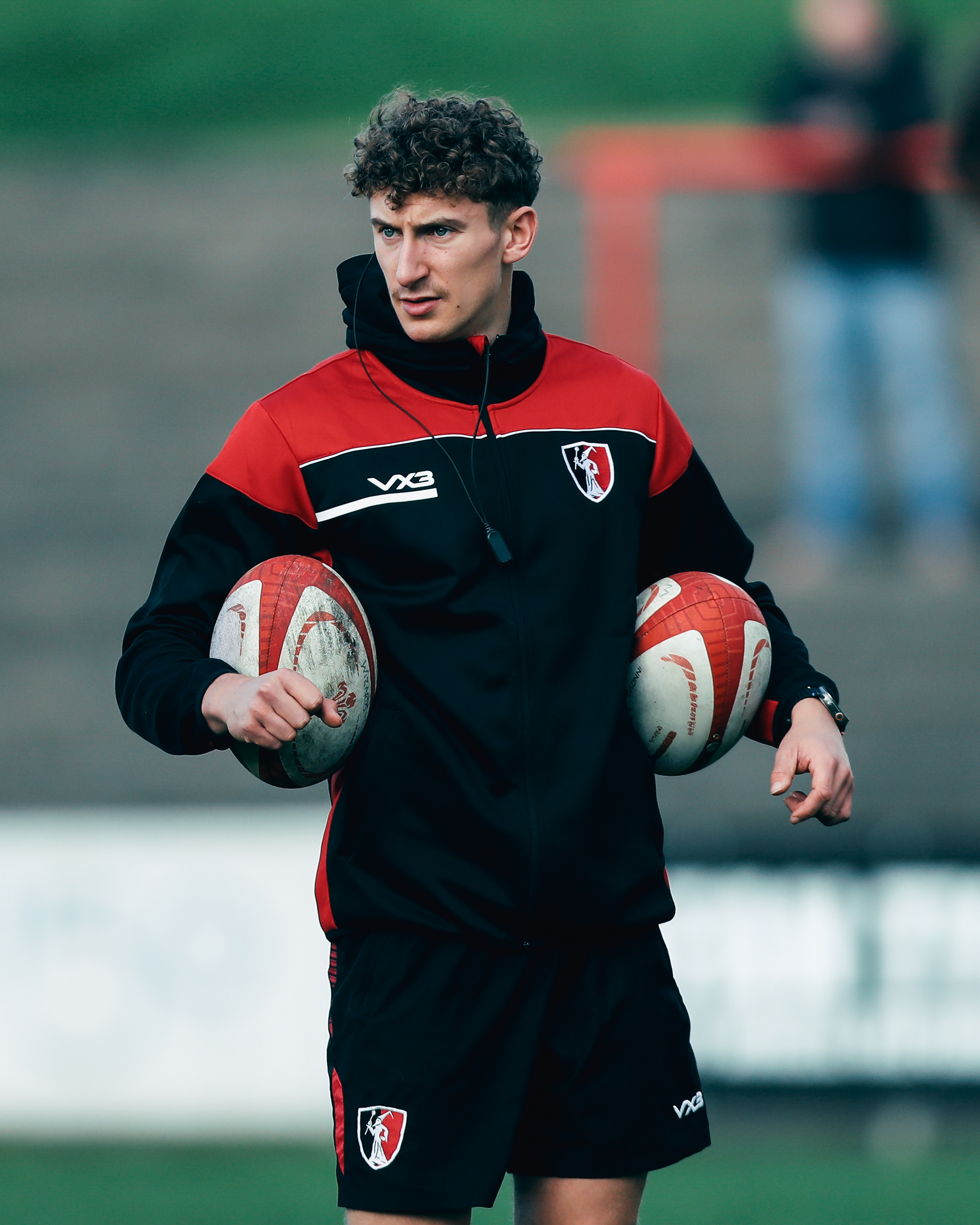 Rugby player wearing a VX3 custom training jacket and shorts with club crest